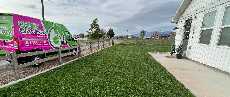 Green lawn in Alpine, UT, and a truck on the street.