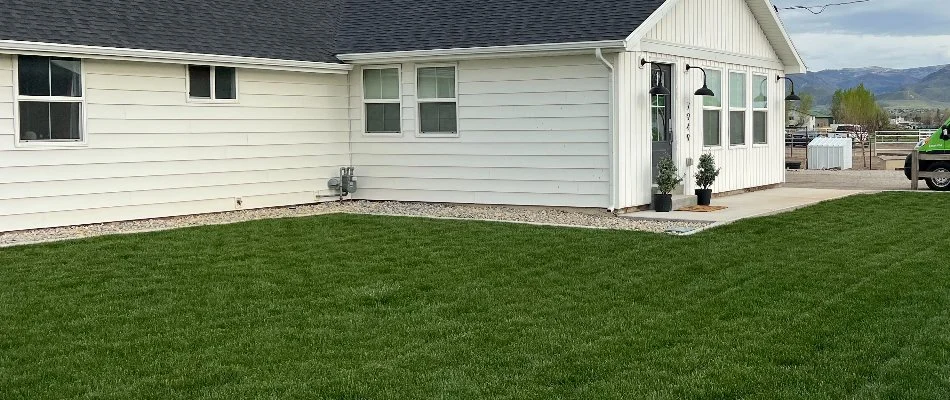 Healthy green lawn on a white property in Cottonwood Heights, UT.